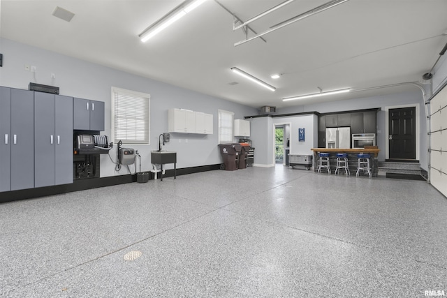 2815 W Windpointe Dr, Peoria, IL 61614 - garage featuring stainless steel fridge with ice dispenser and baseboards