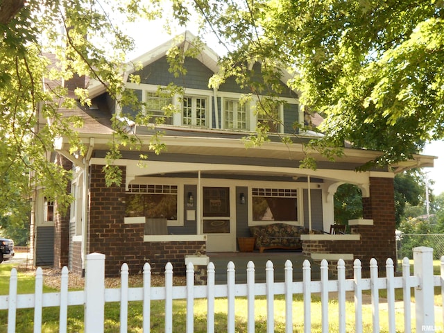 994 N Crafford St, Bushnell, IL 61422 - craftsman-style home featuring covered porch, brick siding, and a fenced front yard