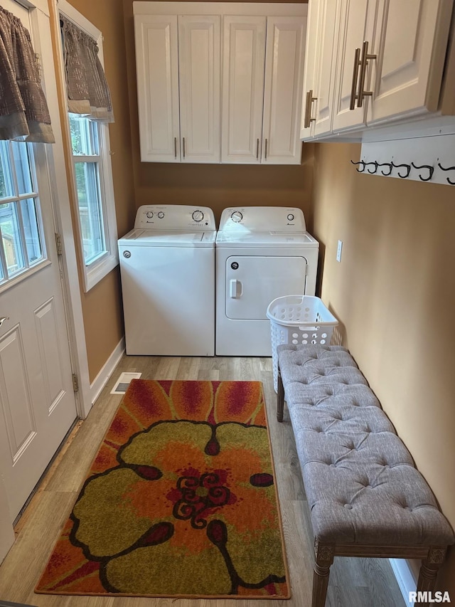 994 N Crafford St, Bushnell, IL 61422 - washroom with washing machine and dryer, light wood-type flooring, and cabinet space