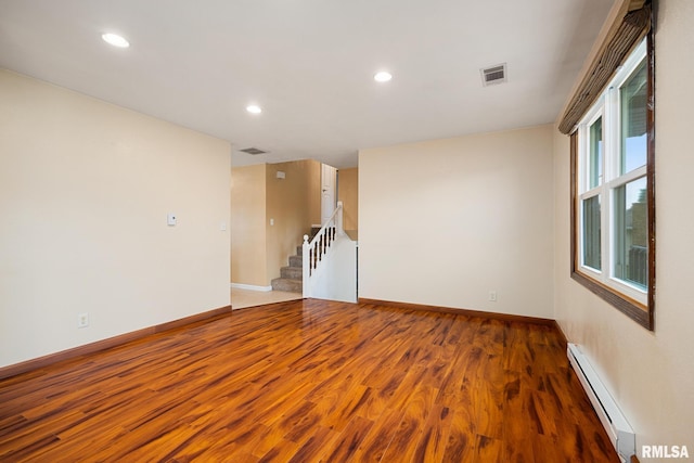 524 Crestview Dr, Metamora, IL 61548 - spare room featuring a baseboard heating unit, wood finished floors, stairway, and recessed lighting