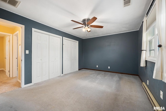 524 Crestview Dr, Metamora, IL 61548 - unfurnished bedroom featuring baseboard heating, carpet floors, multiple closets, and a ceiling fan
