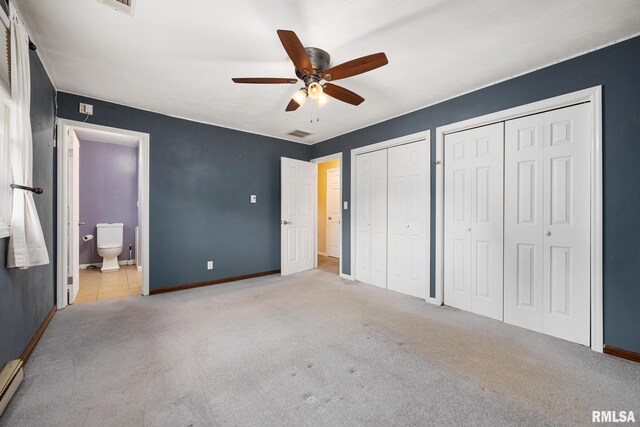 524 Crestview Dr, Metamora, IL 61548 - unfurnished bedroom with two closets, carpet flooring, ensuite bathroom, a baseboard heating unit, and ceiling fan