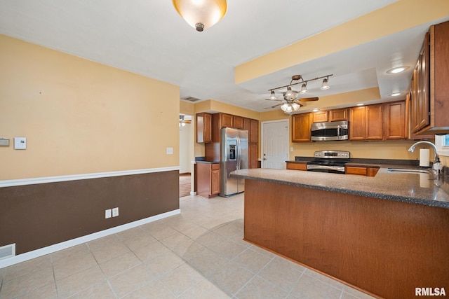 524 Crestview Dr, Metamora, IL 61548 - kitchen with appliances with stainless steel finishes, a ceiling fan, brown cabinets, a peninsula, and light tile patterned flooring