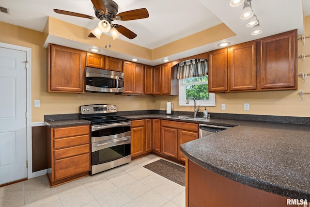 524 Crestview Dr, Metamora, IL 61548 - kitchen with stainless steel appliances, dark countertops, a ceiling fan, brown cabinetry, and light tile patterned floors