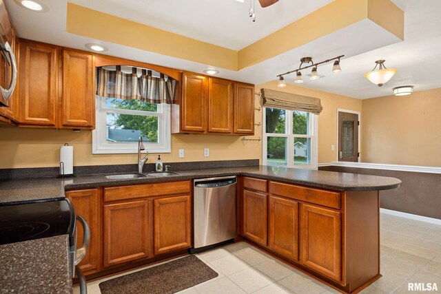 524 Crestview Dr, Metamora, IL 61548 - kitchen with stainless steel appliances, a peninsula, brown cabinetry, track lighting, and light tile patterned floors