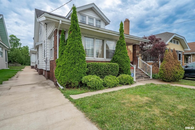 1922 W Rohmann Ave, West Peoria, IL 61604 - bungalow-style home featuring a chimney, a front lawn, and brick siding