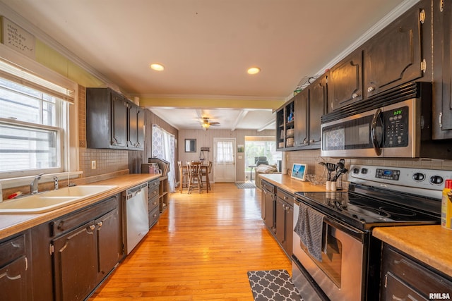 1922 W Rohmann Ave, West Peoria, IL 61604 - kitchen with appliances with stainless steel finishes, light wood-type flooring, tasteful backsplash, dark brown cabinetry, and beamed ceiling