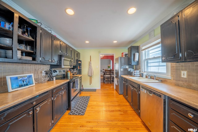 1922 W Rohmann Ave, West Peoria, IL 61604 - kitchen featuring stainless steel appliances, decorative backsplash, light wood finished floors, recessed lighting, and ornamental molding