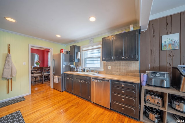1922 W Rohmann Ave, West Peoria, IL 61604 - kitchen with stainless steel appliances, ornamental molding, light countertops, light wood finished floors, and tasteful backsplash