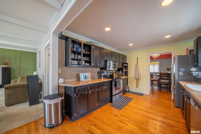1922 W Rohmann Ave, West Peoria, IL 61604 - kitchen with stainless steel appliances, light wood-style flooring, dark brown cabinetry, light countertops, and crown molding