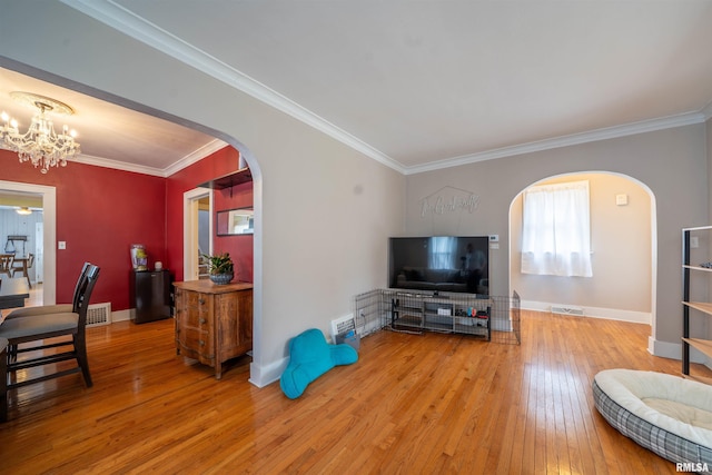 1922 W Rohmann Ave, West Peoria, IL 61604 - living area with arched walkways, hardwood / wood-style floors, ornamental molding, and a chandelier