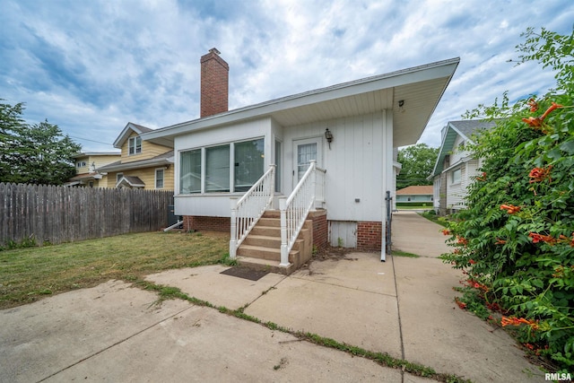 1922 W Rohmann Ave, West Peoria, IL 61604 - back of house with entry steps and a chimney