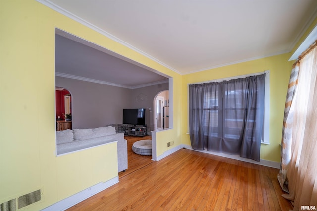 1922 W Rohmann Ave, West Peoria, IL 61604 - unfurnished living room featuring arched walkways, hardwood / wood-style flooring, plenty of natural light, and ornamental molding