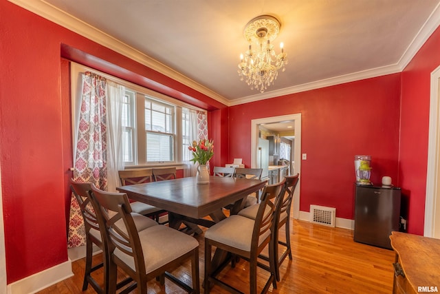 1922 W Rohmann Ave, West Peoria, IL 61604 - dining area featuring a chandelier, light wood-type flooring, and crown molding