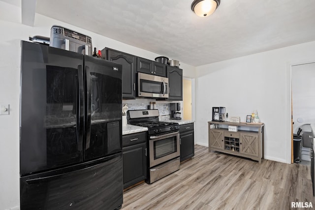 3819 N Saymore Ln, Peoria, IL 61615 - kitchen with appliances with stainless steel finishes, light wood finished floors, and dark cabinetry