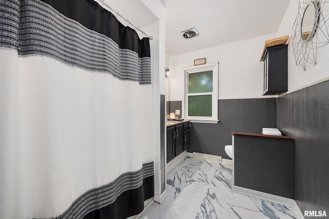 3819 N Saymore Ln, Peoria, IL 61615 - full bathroom featuring vanity, marble finish flooring, wainscoting, and curtained shower