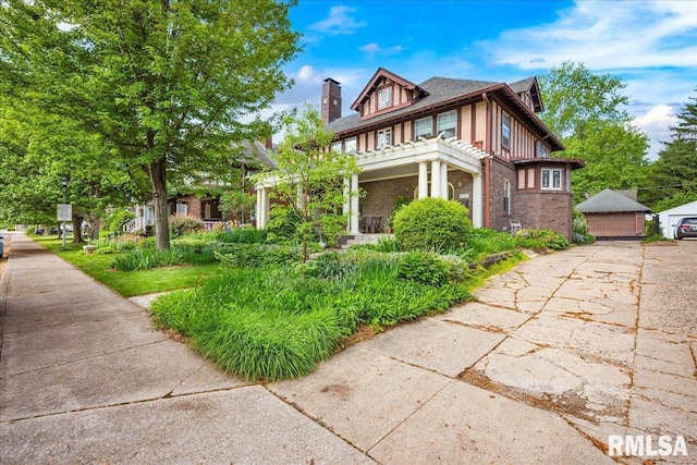 1027 N Maplewood Ave, Peoria, IL 61606 - view of front of house featuring a chimney, brick siding, and an outbuilding