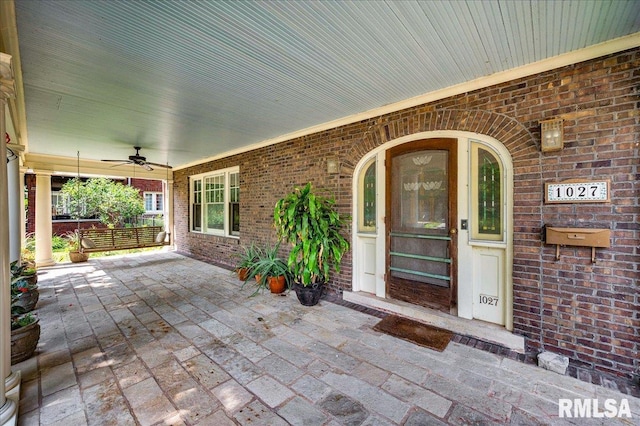 1027 N Maplewood Ave, Peoria, IL 61606 - entrance to property featuring a ceiling fan, brick siding, and covered porch