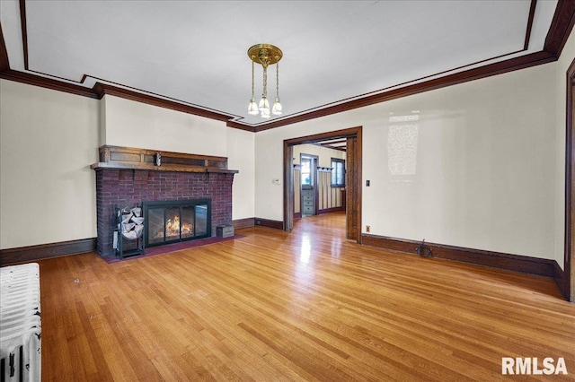 1027 N Maplewood Ave, Peoria, IL 61606 - unfurnished living room featuring ornamental molding, wood finished floors, a fireplace, and a chandelier