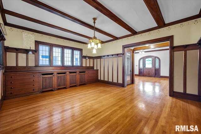 1027 N Maplewood Ave, Peoria, IL 61606 - unfurnished dining area with beam ceiling, light wood-type flooring, arched walkways, and a chandelier