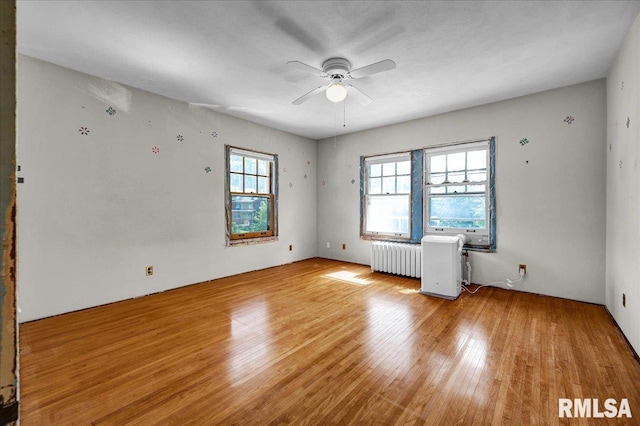 1027 N Maplewood Ave, Peoria, IL 61606 - unfurnished room with radiator, light wood-style flooring, and ceiling fan