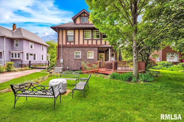 1027 N Maplewood Ave, Peoria, IL 61606 - rear view of house with a lawn, a wooden deck, and brick siding