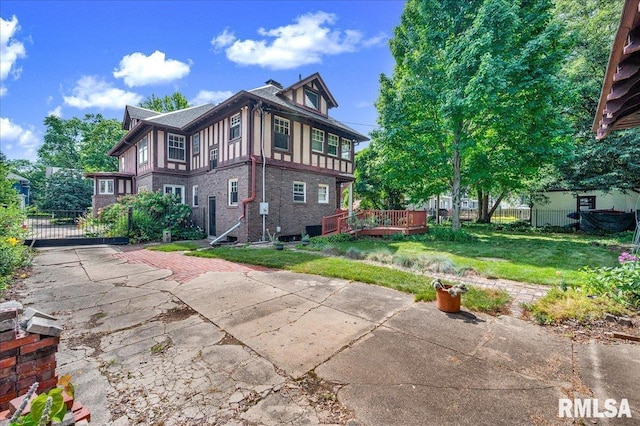 1027 N Maplewood Ave, Peoria, IL 61606 - view of property exterior featuring brick siding, a deck, and a gate