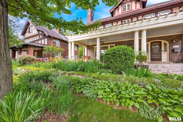 1027 N Maplewood Ave, Peoria, IL 61606 - view of front facade with a porch, brick siding, ceiling fan, and a chimney