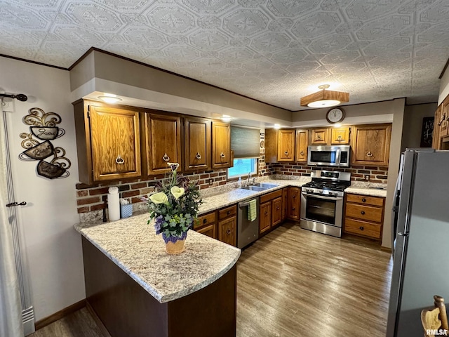 2001 W Jackson St Unit C, Macomb, IL 61455 - kitchen with appliances with stainless steel finishes, a peninsula, brown cabinets, an ornate ceiling, and backsplash
