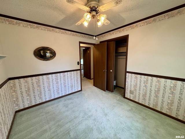 2001 W Jackson St Unit C, Macomb, IL 61455 - unfurnished bedroom with light colored carpet, a textured ceiling, a closet, a ceiling fan, and ornamental molding
