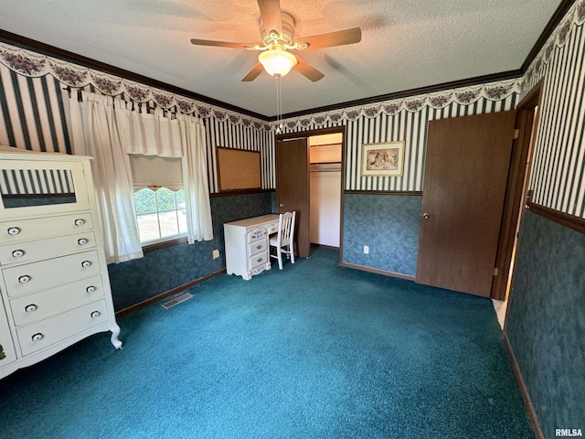 2001 W Jackson St Unit C, Macomb, IL 61455 - unfurnished bedroom featuring wallpapered walls, a textured ceiling, dark carpet, and a ceiling fan