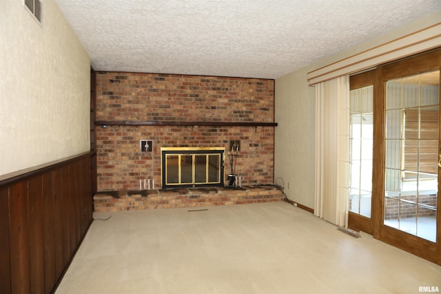 307 N Toepfer St, Tremont, IL 61568 - unfurnished living room featuring a textured ceiling, carpet, a brick fireplace, and a wainscoted wall
