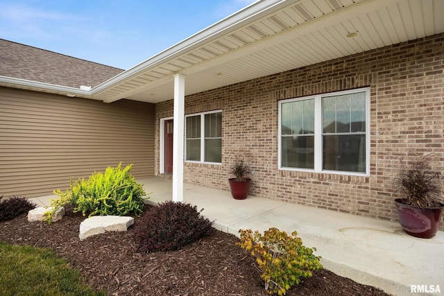 109 E Lee St, Tremont, IL 61568 - doorway to property with brick siding, a patio, and a shingled roof