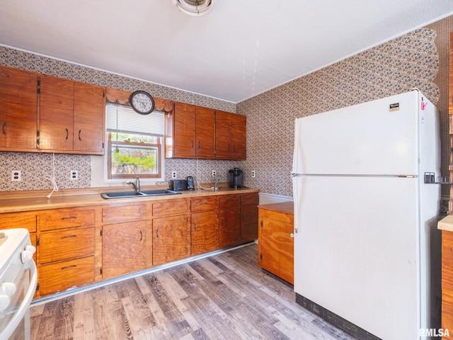 6334 Macs Rd, Manito, IL 61546 - kitchen with freestanding refrigerator, stove, light wood-type flooring, light countertops, and brown cabinetry