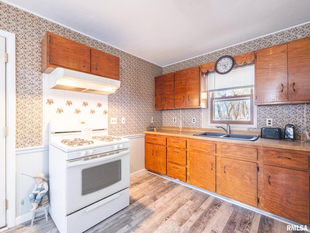 6334 Macs Rd, Manito, IL 61546 - kitchen featuring white stove, under cabinet range hood, light wood-type flooring, brown cabinetry, and wallpapered walls