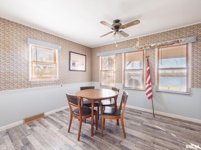 6334 Macs Rd, Manito, IL 61546 - dining area with a wainscoted wall, ceiling fan, wood finished floors, wallpapered walls, and healthy amount of natural light