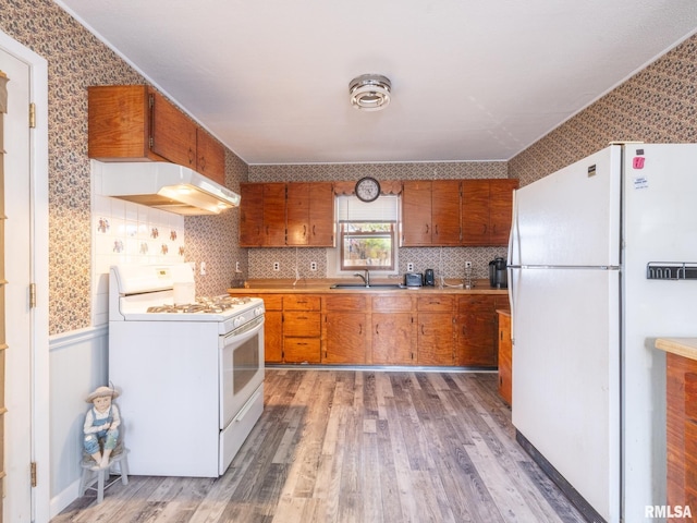 6334 Macs Rd, Manito, IL 61546 - kitchen with white appliances, under cabinet range hood, brown cabinetry, light wood finished floors, and light countertops