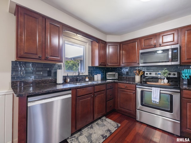 1100 Hampton Rd, Washington, IL 61571 - kitchen with stainless steel appliances, dark wood finished floors, decorative backsplash, dark stone countertops, and wainscoting