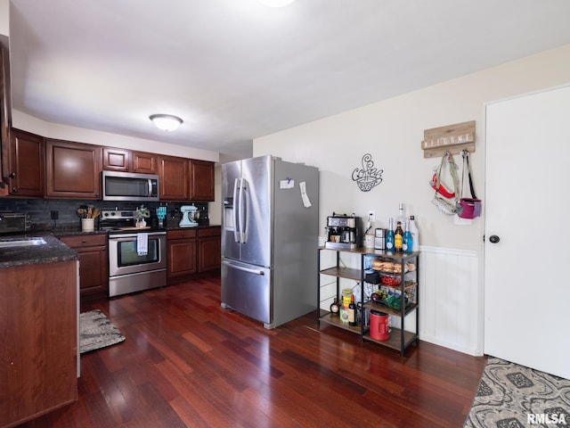1100 Hampton Rd, Washington, IL 61571 - kitchen featuring appliances with stainless steel finishes, dark wood-type flooring, wainscoting, decorative backsplash, and dark stone counters