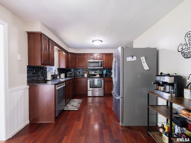 1100 Hampton Rd, Washington, IL 61571 - kitchen with stainless steel appliances, dark wood-style floors, backsplash, a wainscoted wall, and dark stone counters
