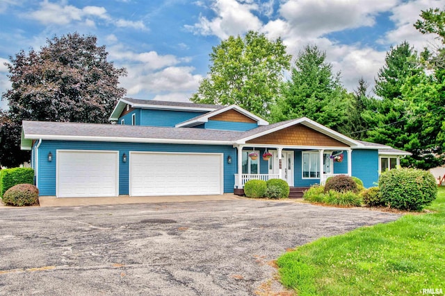 499 Goodsill Dr, East Galesburg, IL 61430 - view of front of home with a porch, a garage, asphalt driveway, and roof with shingles