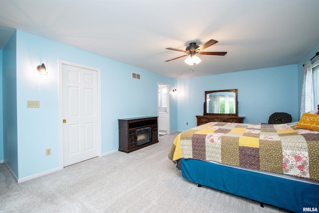 499 Goodsill Dr, East Galesburg, IL 61430 - carpeted bedroom featuring a glass covered fireplace and ceiling fan