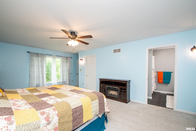 499 Goodsill Dr, East Galesburg, IL 61430 - bedroom with carpet, a glass covered fireplace, ceiling fan, and connected bathroom