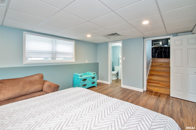 499 Goodsill Dr, East Galesburg, IL 61430 - bedroom with wood finished floors, a paneled ceiling, connected bathroom, and recessed lighting