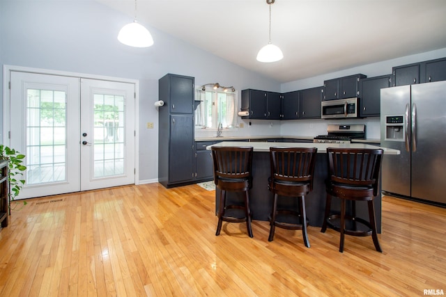499 Goodsill Dr, East Galesburg, IL 61430 - kitchen featuring appliances with stainless steel finishes, light countertops, french doors, vaulted ceiling, and light wood finished floors