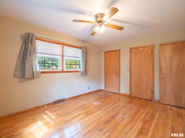 204 Ivanhoe Way, Bloomington, IL 61701 - unfurnished bedroom with wood finished floors, multiple closets, and a ceiling fan