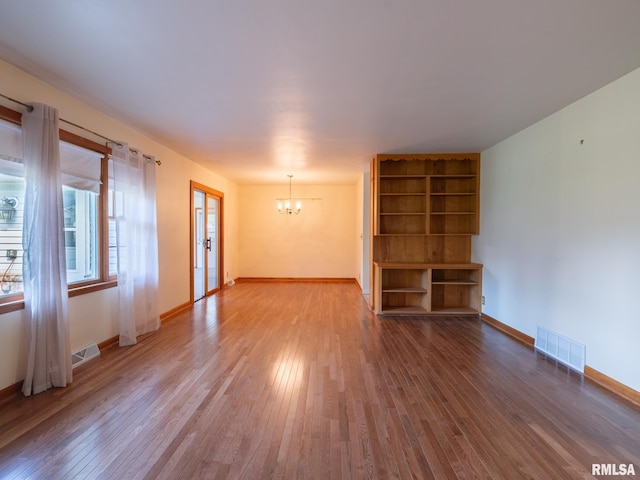 204 Ivanhoe Way, Bloomington, IL 61701 - unfurnished living room featuring a chandelier, wood-type flooring, and french doors