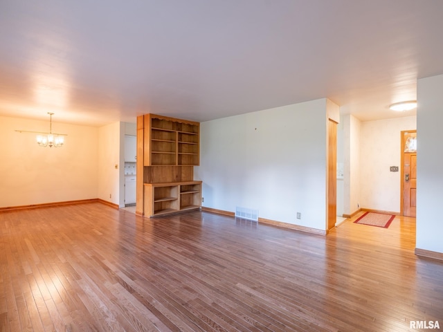 204 Ivanhoe Way, Bloomington, IL 61701 - unfurnished living room with a chandelier and hardwood / wood-style flooring