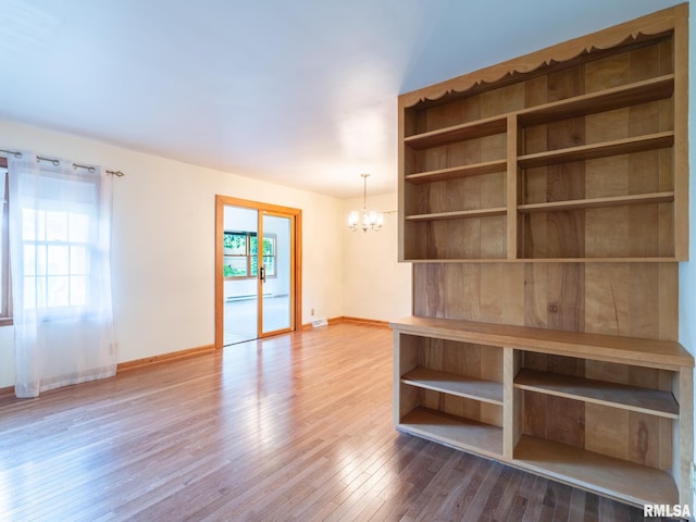 204 Ivanhoe Way, Bloomington, IL 61701 - empty room with a chandelier and wood finished floors