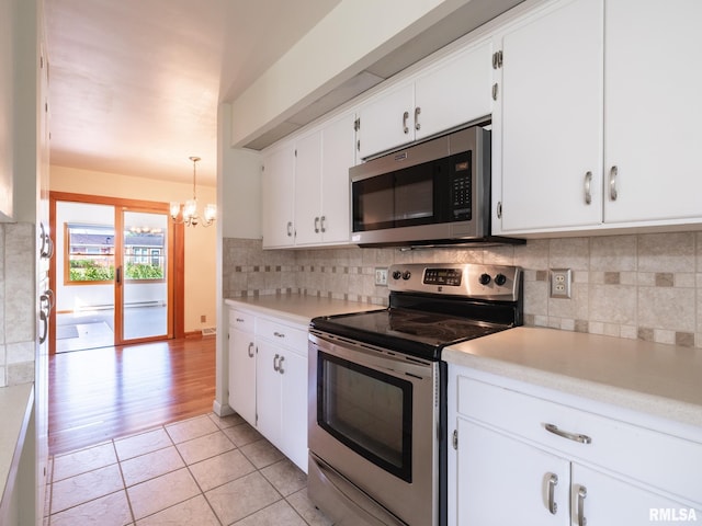 204 Ivanhoe Way, Bloomington, IL 61701 - kitchen featuring appliances with stainless steel finishes, a chandelier, light countertops, white cabinetry, and decorative backsplash